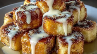 Delicious cinnamon roll french toast bites served on a plate with syrup and icing
