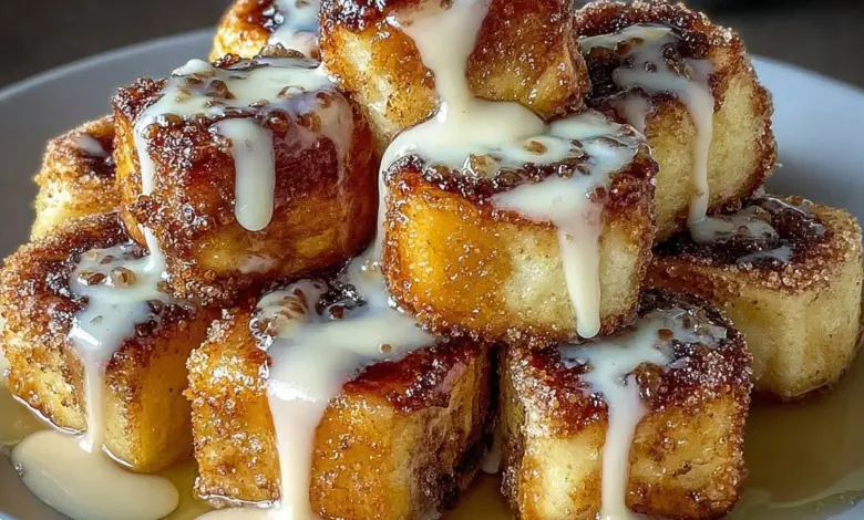 Delicious cinnamon roll french toast bites served on a plate with syrup and icing