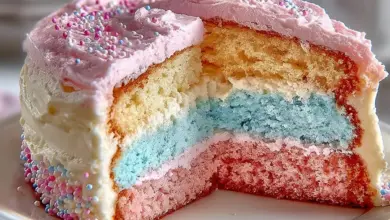 A stunning cotton candy cake topped with fluffy pink and blue cotton candy.