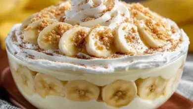 Delicious homemade easy banana pudding in a glass dish with whipped cream and bananas