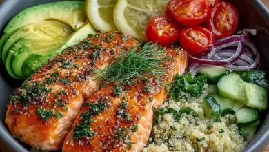 Lemon herb salmon served in a quinoa bowl with avocado and fresh herbs