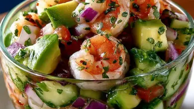 Colorful Mexican shrimp cocktail served in a glass with fresh lime and avocado.