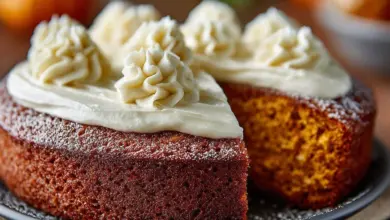 Slice of moist pumpkin cake topped with cream cheese frosting on a rustic plate