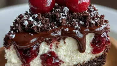 Slice of Black Forest Cheesecake topped with chocolate shavings and cherries