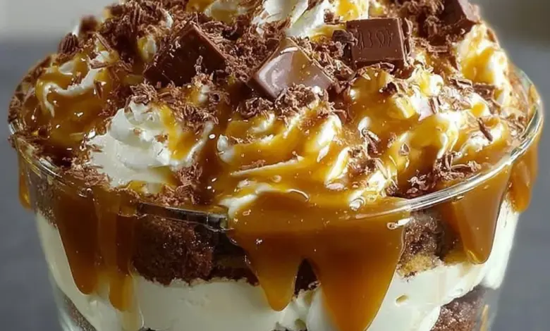 Delicious caramel cheesecake brownie trifle dessert with layers of chocolate and cream.