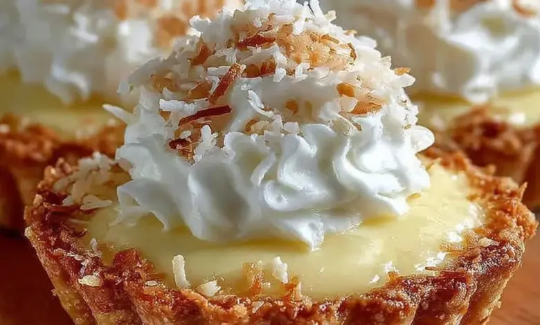 Delicious mini coconut cream pies topped with whipped cream and coconut flakes.