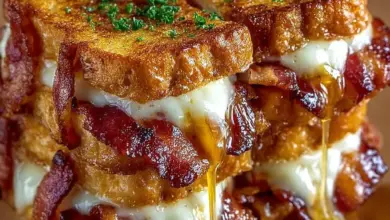 Bacon-wrapped grilled cheese fingers served on a plate with dipping sauce