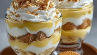 Delicious banana pudding cups topped with whipped cream and banana slices
