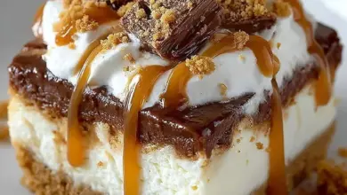 Delicious Butterfinger Caramel Cheesecake topped with caramel and chocolate.
