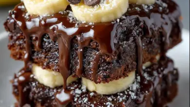 Delicious chocolate covered banana brownies topped with bananas and chocolate glaze.