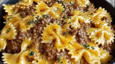 Plate of creamy Velveeta beef pasta with bowtie noodles garnished with herbs