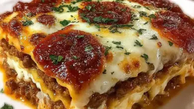 A delicious slice of Pizza Lasagna topped with melted cheese and fresh herbs